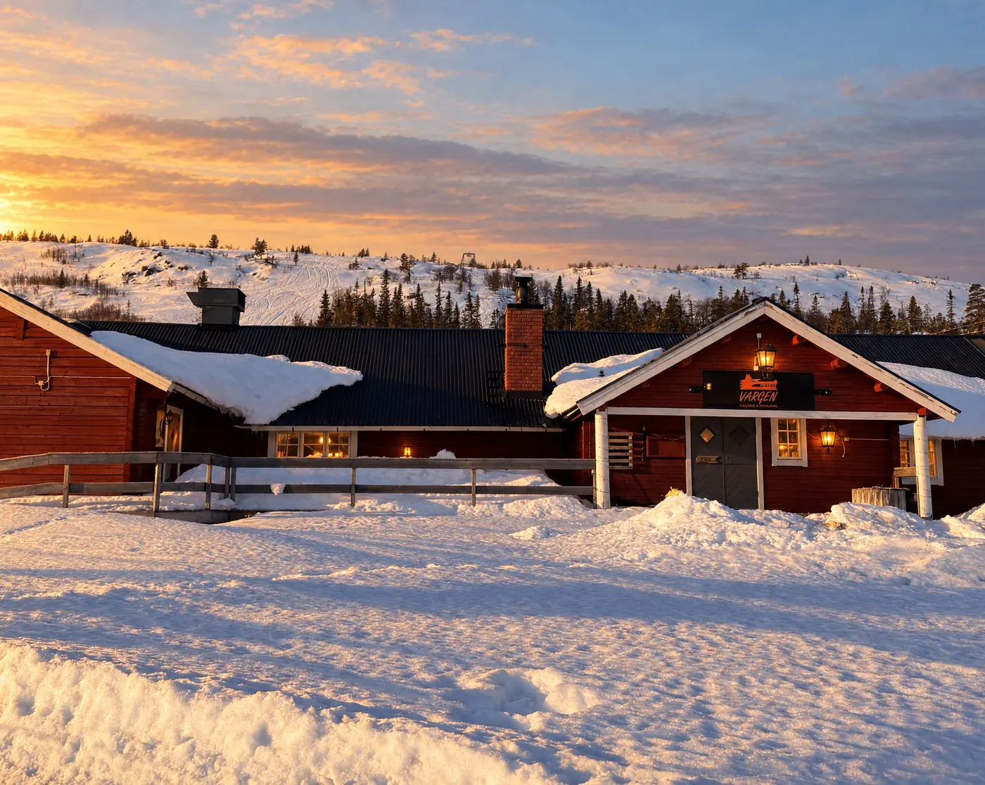 Vargens hus i snö i eftermiddagssol, fjället bakom